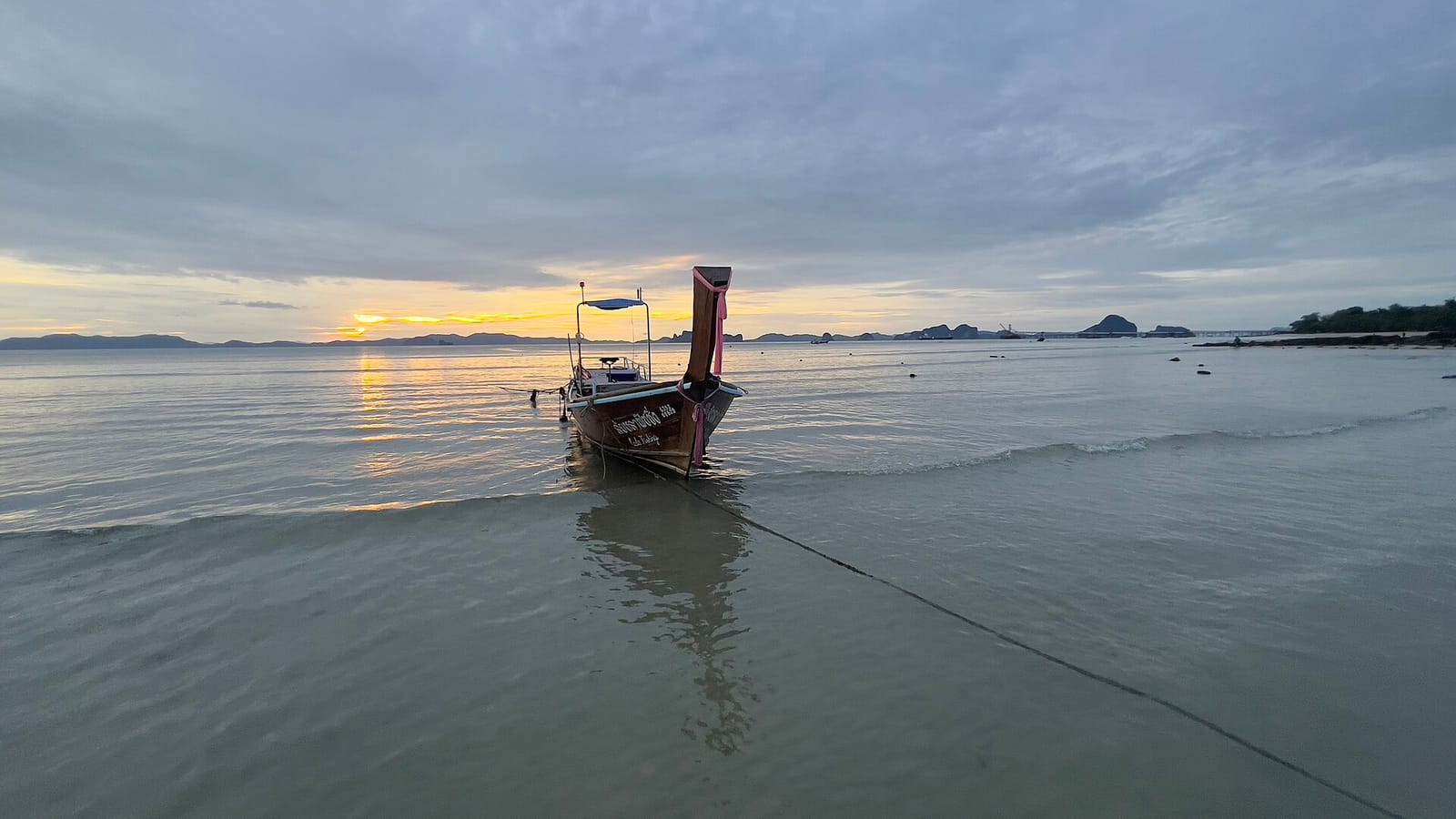 Klong Muang beach in Krabi, a wide sandy shore with a limestone island across calm water