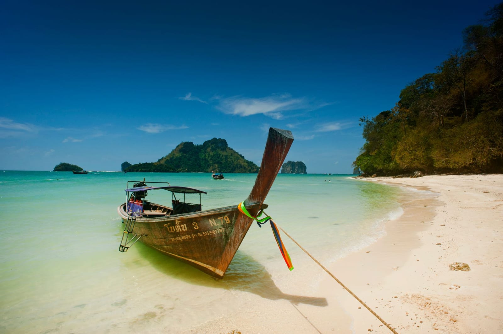 Longtail boats pulled up on the sand at Ao Nang beach, the working harbour the hotels face
