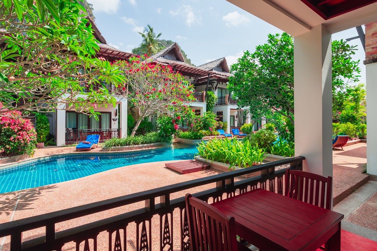 Pool and tropical gardens at Railay Village Resort and Spa with limestone cliffs rising above the Railay peninsula in Krabi Pool and tropical gardens at Railay Village Resort and Spa with limestone cliffs rising above the Railay peninsula in Krabi